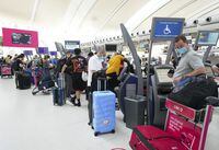 People wait in line to check in at Pearson International Airport in Toronto on May 12, 2022.