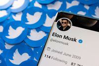 FILE PHOTO: Elon Musk's Twitter profile is seen on a smartphone placed on printed Twitter logos in this picture illustration taken April 28, 2022. REUTERS/Dado Ruvic/Illustration/File Photo