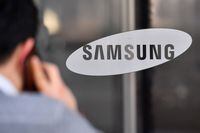 (FILES) This file photo taken on January 8, 2019, shows a man stading in front of the logo of Samsung Electronics at the Samsung building in Seoul. - Ten tech giants meet the criteria to be deemed online "gatekeepers" under proposed tougher EU competition rules, a source close to the European Commission told AFP on December 15, 2020. The firms that would be subject to stricter regulation are US titans Facebook, Google, Amazon, Apple, Microsoft and SnapChat; China's Alibaba and Bytedance, South Korea's Samsung and the Netherlands' Booking. (Photo by Jung Yeon-je / AFP) (Photo by JUNG YEON-JE/AFP via Getty Images)