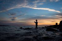 Rick Yen is silhouetted as he casts a rod while fishing for salmon near the mouth of the Capilano River off Ambleside Park at sunset in West Vancouver, B.C., on Tuesday August 25, 2015. In April, Federal Fisheries Minister Jonathan Wilkinson announced a recreational catch-and-release fishery until mid-July to allow maximum numbers of chinook salmon to reach their spawning grounds, followed by catch retention limits of up to two chinook depending on the fishing area and time of year. THE CANADIAN PRESS/Darryl Dyck