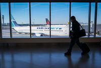 Passengers walk past Air Canada and WestJet planes at Calgary International Airport in Calgary, Alta., Wednesday, Aug. 31, 2022. WestJet flights from Halifax to Montreal will be suspended as of Oct. 28 with several Eastern and Atlantic routes to follow.THE CANADIAN PRESS/Jeff McIntosh
