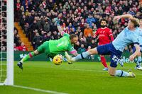 Liverpool's Mohamed Salah, back, scores his side's opening goal during the English Premier League soccer match between Liverpool and Brentford at Anfield stadium in Liverpool, England, Sunday, Nov. 12, 2023. (AP Photo/Jon Super)