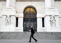 FILE PHOTO: A woman passes the Italian Stock Exchange in Milan, Italy, February 25, 2020. REUTERS/Flavio Lo Scalzo/File Photo