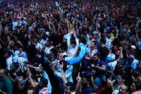 Fans of Argentina celebrate a goal as they watch in a giant screen the World Cup group C soccer match between Argentina and Mexico being played at the Lusail stadium, in Doha, Qatar, Saturday, Nov. 26, 2022. Argentina won 2-0. (AP Photo/Francisco Seco)