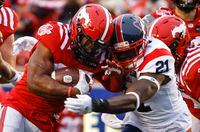 Montreal Alouettes linebacker Chris Ackie, right, tackles Calgary Stampeders running back Ka'Deem Carey during second half CFL football action in Calgary, Thursday, June 9, 2022.THE CANADIAN PRESS/Jeff McIntosh
