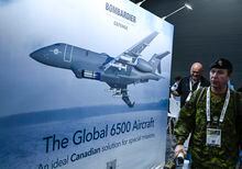 Attendees pass an image of the Bombardier Global 6500 Aircraft at the CANSEC trade show, billed as North America’s largest multi-service defence event, in Ottawa, on Wednesday, May 31, 2023. THE CANADIAN PRESS/Justin Tang
