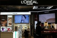FILE PHOTO: Staff members work at a counter of cosmetics brand L’Oreal at a shopping mall in Beijing, China November 18, 2021. REUTERS/Tingshu Wang/File Photo