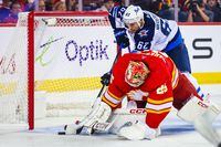 Oct 11, 2023; Calgary, Alberta, CAN; Calgary Flames goaltender Jacob Markstrom (25) makes a save as Winnipeg Jets right wing Nino Niederreiter (62) tries to score during the third period at Scotiabank Saddledome. Mandatory Credit: Sergei Belski-USA TODAY Sports
