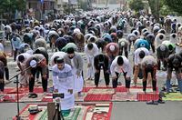 Muslim men perform Eid al-Fitr prayer marking the end of the holy fasting month of Ramadan on a street in Jakarta, Indonesia, Thursday, May 13, 2021. (AP Photo/Dita Alangkara)