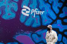 FILE - A man walks by Pfizer headquarters, Friday, Feb. 5, 2021, in New York. Pfizer will spend about $43 billion to buy Seagen and broaden its reach into cancer treatments, the pharmaceutical giant said Monday, March 13, 2023. (AP Photo/Mark Lennihan, File)