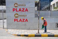 A man waters a tree outside the Jio World Centre during a government-imposed nationwide lockdown as a preventive measure against the spread of the COVID-19 coronavirus, in Navi Mumbai on April 22, 2020. - Facebook has taken a $5.7 billion stake in the Jio digital platforms business of India's richest man Mukesh Ambani, the two sides said on April 22, marking one of the biggest foreign investments in the country. The deal will give the US social media giant a 10 percent stake in Jio Platforms, part of Ambani's Reliance Industries empire. (Photo by INDRANIL MUKHERJEE / AFP) (Photo by INDRANIL MUKHERJEE/AFP via Getty Images)