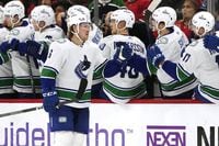 Vancouver Canucks right wing Brock Boeser (6) celebrates with teammates after scoring his goal during the second period of an NHL hockey game against the Chicago Blackhawks in Chicago, Sunday, Dec. 17, 2023. (AP Photo/Nam Y. Huh)