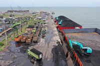 Heavy machinery (R) is used to load coal onto trucks at the Karya Citra Nusantara (KCN) Marunda port in Jakarta on January 17, 2022, after Indonesia eased an export ban on the commodity. (Photo by ADEK BERRY / AFP) (Photo by ADEK BERRY/AFP via Getty Images)