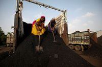 FILE PHOTO: Workers unload coal from a supply truck at a yard on the outskirts of Ahmedabad, India October 12, 2021. REUTERS/Amit Dave