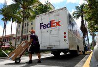 MIAMI BEACH, FLORIDA - SEPTEMBER 16:  A FedEx worker makes a delivery on September 16, 2022 in Miami Beach, Florida. Shares of FedEx fell after the company missed estimates on revenue and earnings in its first quarter. (Photo by Joe Raedle/Getty Images)