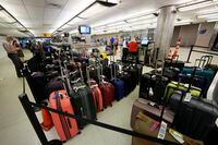 Baggage stacks up from delayed travellers in the baggage claim area in Denver International Airport Wednesday, June 16, 2021, in Denver.  The Biden administration is planning to require that airlines refund fees on checked baggage if the bags get seriously delayed. The proposal would also require refunds for fees on extras like internet access if the airline fails to provide the service during the flight.   (AP Photo/David Zalubowski)