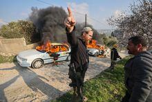 A member of security for the Israeli Bracha settlement gestures amid clashes between settlers and Palestinians in Burin village, after settlers reportedly set cars on fire in the village in the occupied West Bank on February 25, 2023. (Photo by JAAFAR ASHTIYEH / AFP) (Photo by JAAFAR ASHTIYEH/AFP via Getty Images)