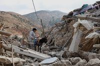 Fatima Belkas stands next to a donkey surrounded by her devastated town days after the deadly earthquake, in Adouz, Morocco September 12, 2023. REUTERS/Emilie Madi