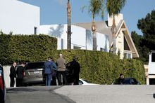 Police investigators stand in a street near a house where three people were killed and four others wounded in a shooing at a short-term rental home in an upscale Los Angeles neighborhood on Saturday Jan. 28, 2023. (AP Photo/Richard Vogel)