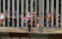FILE PHOTO: Migrants stand near the wall on Polish Belarusian border near Bialowieza, Poland May 28, 2023. Agnieszka Sadowska/Agencja Wyborcza.pl via REUTERS