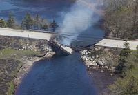 The collapsed bridge between Clyde River and Port Clyde smoulders in Nova Scotia.