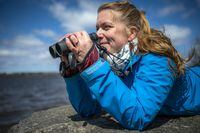 Jennifer Provencher, wildlife health specialist with Environment and Climate Change Canada, at Westboro Beach in Ottawa, Wednesday, April 20, 2022. Provencher looks out over the Ottawa River with her binoculars Wednesday. Photo by Ashley Fraser/Globe and Mail