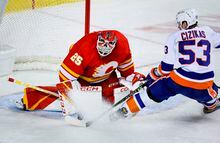 New York Islanders forward Casey Cizikas, right, tries to score on a breakaway as Calgary Flames goalie Jacob Markstrom blocks him during second period NHL hockey action in Calgary, Friday, Jan. 6, 2023.THE CANADIAN PRESS/Jeff McIntosh