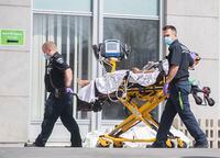 Paramedics bring a person into a hospital in Montreal, Sunday, April 11, 2021, as the COVID-19 pandemic continues in Canada and around the world. THE CANADIAN PRESS/Graham Hughes