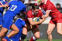 Canada's Alysha Corrigan, second right, carries the ball as France's Maelle Filopon, left, comes in to help in the tackle in the bronze medal game of the women's rugby World Cup at Eden Park in Auckland, New Zealand, Saturday, Nov.12, 2022. (Andrew Cornaga/Photosport via AP)
