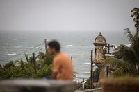 A man stands in front of a beach before the arrival of Tropical Storm Fiona in San Juan, Puerto Rico, Saturday, Sept. 17, 2022. Fiona was expected to become a hurricane as it neared Puerto Rico on Saturday, threatening to dump up to 20 inches (51 centimeters) of rain as people braced for potential landslides, severe flooding and power outages. (AP Photo/Alejandro Granadillo)