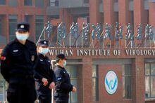 FILE PHOTO: FILE PHOTO: Security personnel keep watch outside the Wuhan Institute of Virology during the visit by the World Health Organization (WHO) team tasked with investigating the origins of the coronavirus disease (COVID-19), in Wuhan, Hubei province, China February 3, 2021. REUTERS/Thomas Peter/File Photo/File Photo