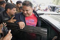 Fawad Chaudhry, center, a senior leader of former Prime Minister Imran Khan's party, leaves after his medial checkup at a hospital in Lahore, Pakistan, Wednesday, Jan. 25, 2023. Police in Pakistan arrested a senior leader of former Prime Minister Imran Khan's party on charges of threatening the chief of the elections overseeing body and other government officials. (AP Photo/K.M. Chaudary)
