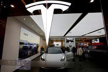 FILE PHOTO: FILE PHOTO: Visitors check a Tesla Model 3 car next to a Model Y displayed at a showroom of the U.S. electric vehicle (EV) maker in Beijing, China February 4, 2023. REUTERS/Florence Lo