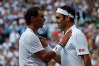 (FILES) In this file photo taken on July 12, 2019 Switzerland's Roger Federer (R) speaks with Spain's Rafael Nadal (L) after Federer won their men's singles semi-final match on day 11 of the 2019 Wimbledon Championships at The All England Lawn Tennis Club in Wimbledon, southwest London. - Roger Federer said on September 21, 2022 he wants to team up with long-time rival Rafael Nadal for the final match of his career at the Laver Cup in London. (Photo by Adrian DENNIS / POOL / AFP) / RESTRICTED TO EDITORIAL USE (Photo by ADRIAN DENNIS/POOL/AFP via Getty Images)