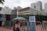 A woman shields herself from the rain as she walks past U.S. Consulate in Guangzhou, China June 7, 2018. REUTERS/Sue-Lin Wong