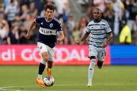 Vancouver Whitecaps midfielder Alessandro Schöpf (8) is chased by Sporting Kansas City midfielder Gadi Kinda (10) as he moves the ball during the first half of an MLS soccer match Saturday, July 1, 2023, in Kansas City, Kan. (AP Photo/Charlie Riedel)