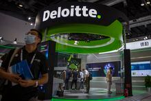 A visitor walks past a booth from accounting firm Deloitte at the China International Fair fro Trade in Services (CIFTIS) in Beijing, Saturday, Sept. 5, 2020. The Beijing office of Deloitte Touche Tohmatsu has been fined $30.8 million for failing to adequately audit a Chinese state-owned asset management company whose former head was sentenced to death on corruption charges. The office also was ordered to suspend operations for three months for mishandling audit and other work at China Huarong Asset Management Co. in 2014-19, the Ministry of Finance announced Friday March 17, 2023. (AP Photo/Mark Schiefelbein)