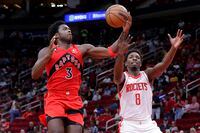 Toronto Raptors forward OG Anunoby (3) pulls in a rebound over Houston Rockets forward Jae'Sean Tate (8) during the second half of a preseason NBA basketball game Friday, Oct. 7, 2022, in Houston. (AP Photo/Michael Wyke)