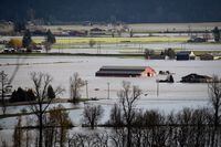 A boat travels across flooded farmland in Abbotsford, B.C., on Tuesday, Nov. 16, 2021.