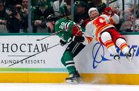 DALLAS, TEXAS - MAY 09: Trevor Lewis #22 of the Calgary Flames is knocked into the boards by Ryan Suter #20 of the Dallas Stars in the first period in Game Four of the First Round of the 2022 Stanley Cup Playoffs at American Airlines Center on May 09, 2022 in Dallas, Texas. (Photo by Richard Rodriguez/Getty Images)