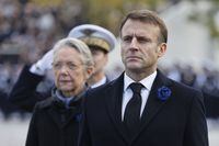 French President Emmanuel Macron, flanked by French Prime Minister Elisabeth Borne, attend a ceremony at the Arc de Triomphe, as part of the commemorations marking the105th anniversary of the Nov. 11, 1918 Armistice, ending World War I, Saturday, Nov. 11, 2023 in Paris. (Ludovic Marin/Pool via AP)