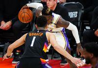 May 23, 2021; Phoenix, Arizona, USA; Los Angeles Lakers guard Dennis Schroder (17) controls the ball against Phoenix Suns guard Devin Booker (1) during game one in the first round of the 2021 NBA Playoffs at Phoenix Suns Arena. Mandatory Credit: Mark J. Rebilas-USA TODAY Sports
