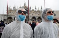 Tourists wear protective face masks at Venice Carnival, which the last two days of, as well as Sunday night's festivities, have been cancelled because of an outbreak of coronavirus, in Venice, Italy February 23, 2020. REUTERS/Manuel Silvestri