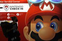FILE - A person passes an ad featuring the Nintendo character Mario at Narita airport in Narita near Tokyo on June 10, 2022. Charles Martinet, the voice of Mario in Nintendo games since the 1990s, is stepping down, Nintendo of America confirmed Monday, Aug. 21. (AP Photo/Shuji Kajiyama, File)