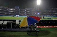 A broadcast team member walks with a big umbrella as VIVO IPL cricket T20 match between Rajasthan Royals and Delhi Daredevils is stopped due to rain in New Delhi, India, Wednesday, May 2, 2018. (AP Photo/Altaf Qadri)