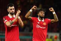 Manchester United's Bruno Fernandes, left, and Manchester United's Fred applaud fans at the end of the Europa League playoff second leg soccer match between Manchester United and Barcelona at Old Trafford stadium in Manchester, England, Thursday, Feb. 23, 2023. Manchester United won 2-1. (AP Photo/Dave Thompson)