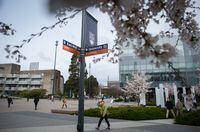 A woman walks past a street sign at the University of British Columbia, in Vancouver, B.C., on Wednesday April 4, 2018. Signs on nine major campus streets are being replaced with the bilingual signs that acknowledge and respect the traditional territory of the Musqueam people. UBC's Point Grey Campus is located on their traditional territory. Darryl Dyck/The Globe and Mail