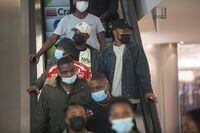 People wearing masks on an escalator at a shopping mall, in Johannesburg, South Africa, Friday Nov. 26, 2021. Advisers to the World Health Organization are holding a special session Friday to flesh out information about a worrying new variant of the coronavirus that has emerged in South Africa, though its impact on COVID-19 vaccines may not be known for weeks. (AP Photo/Denis Farrell)