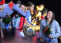 Gold medallist Canada's Summer McIntosh (2nd L) receives a hug as silver medallist USA's Hali Flickinger (R) holds flowers following the women's 200m butterfly finals during the Budapest 2022 World Aquatics Championships at Duna Arena in Budapest on June 22, 2022. (Photo by Ferenc ISZA / AFP) (Photo by FERENC ISZA/AFP via Getty Images)