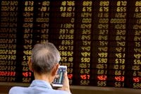 A man monitors stock prices at a brokerage in Beijing on Tuesday, June 25, 2019.